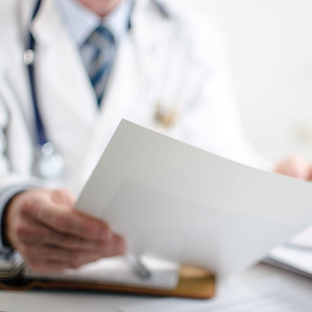 Doctor reading medical notes at his office